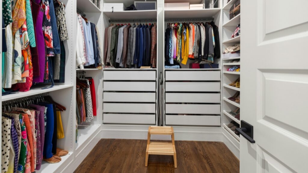 Residential cleaning team organizing a walk-in closet for a tidy, clutter-free home.