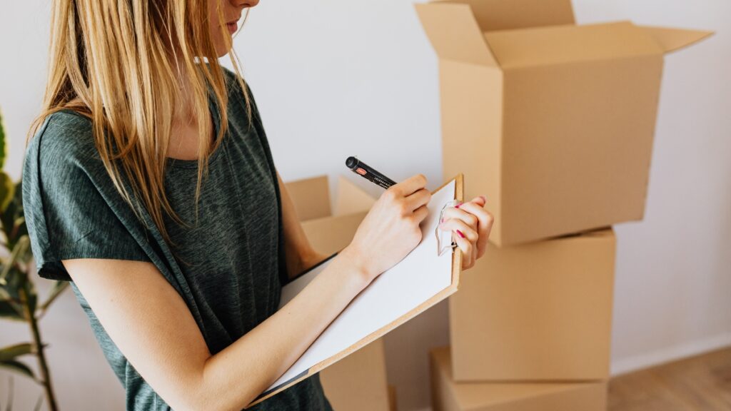 Woman organizing moving boxes for residential cleaning services.